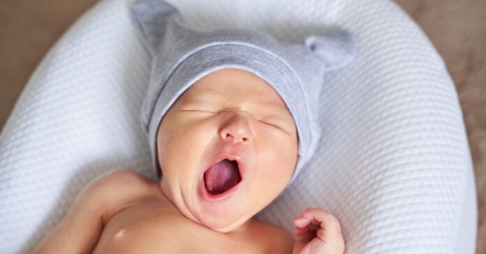 A baby yawning with a wide-open mouth.